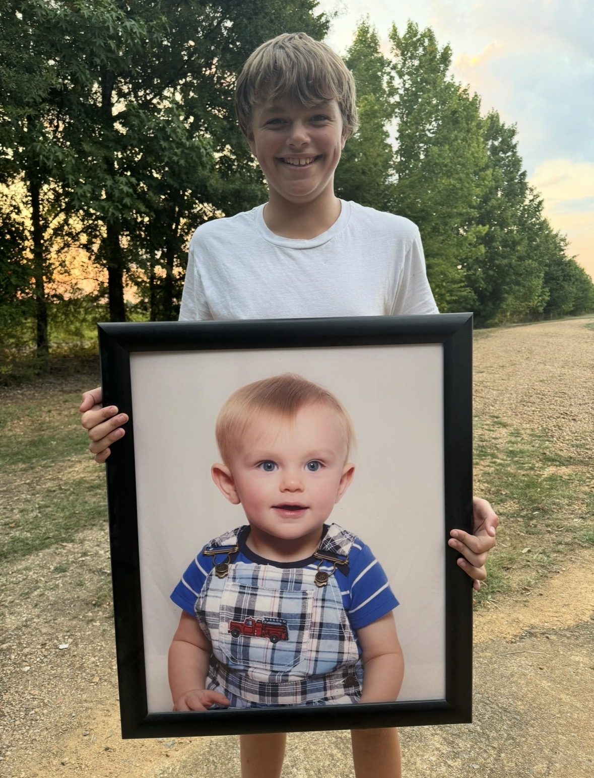 Connor holding a framed photo of himself as a toddler