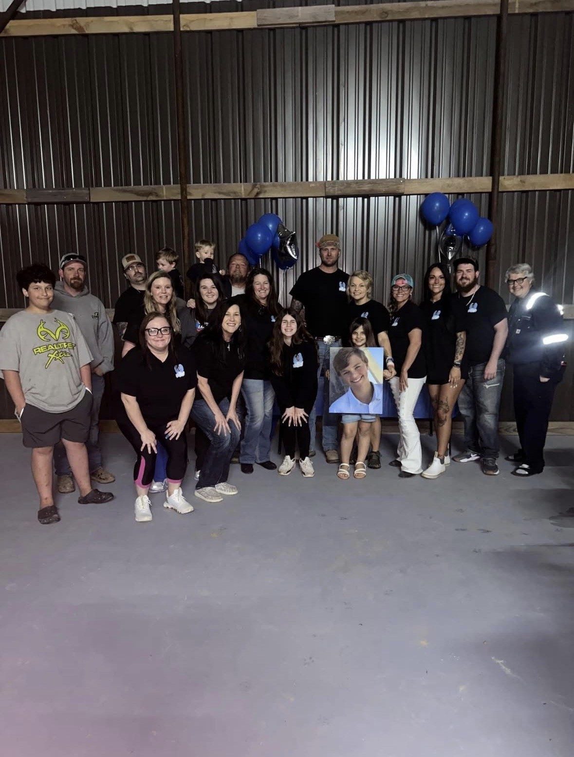 The Forever 13 family together at an event, holding Connor's portrait