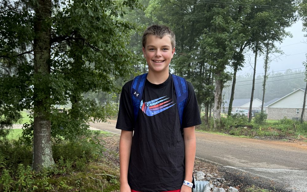 Connor smiling outdoors with his backpack on